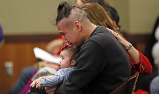 Savanna LaFontaine-Greywind's boyfriend Ashton Matheny holds their daughter, Haisley Jo, as victim impact statements are read during the sentencing of Brooke Crews at the Class County District Court of February 2, 2018. David Samson / The Forum