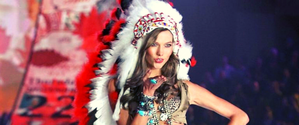 pretendians fake indian white woman model wearing native american headdress at fashion show
