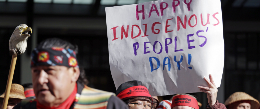 native american man in crowd protesting against columbus day and for indigenous peoples day