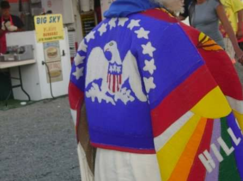 Ernestine Gopher beadced emblem of Indian Peace Flag and the memory of Hill 57 onto her buckskin dress.