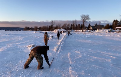 Volunteers prepare the track the night before the Inter-Tribal Snow Snake Festival, held Feb. 5, 2022 on Madeline Island. The traditional game of snow snake - a popular winter event among the Ojibwe, Ho-Chunk, Oneida and other northern tribal nations, is facing renewed interest. (Photo by Dan Ninham for Indian Country Today)