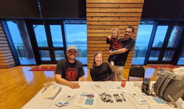 From left, Robert Coberly, Tulalip, tribal crisis counselor; Heaven Arbuckle, Tulalip, tribal crisis counselor lead; and Arbuckle's husband, Brandon Hachett, Tulalip, holding their son Roman. The group had an information table for the Native and Strong Lifeline at a recent Missing and Murdered Indigenous People event in Tulalip, Washington. (Photo courtesy of Native and Strong Lifeline)