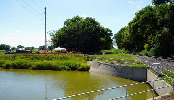 The dig site at the Genoa Boarding School can be seen on Wednesday, July 12, 2023 on the other side of a canal that was built following the school's closure in 1934. Railroad tracks also can be seen just to the north of the dig site. (Kevin Abourezk, ICT News)
