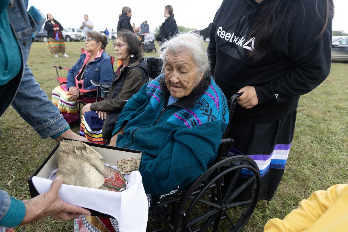 Kelley Bova (not shown) shows the moccasins to Helena Little Ghost at the Lake Traverse Reservation in South Dakota on Sept. 23, 2023.  The moccasins were confiscated from a student at the Carlisle Indian Industrial School more than 100 years ago. They remained in the possession of a Pennsylvania family for more than a century before being repatriated back to the Sisseton Wahpeton Oyate. (Photo by Charles Fox for ICT)