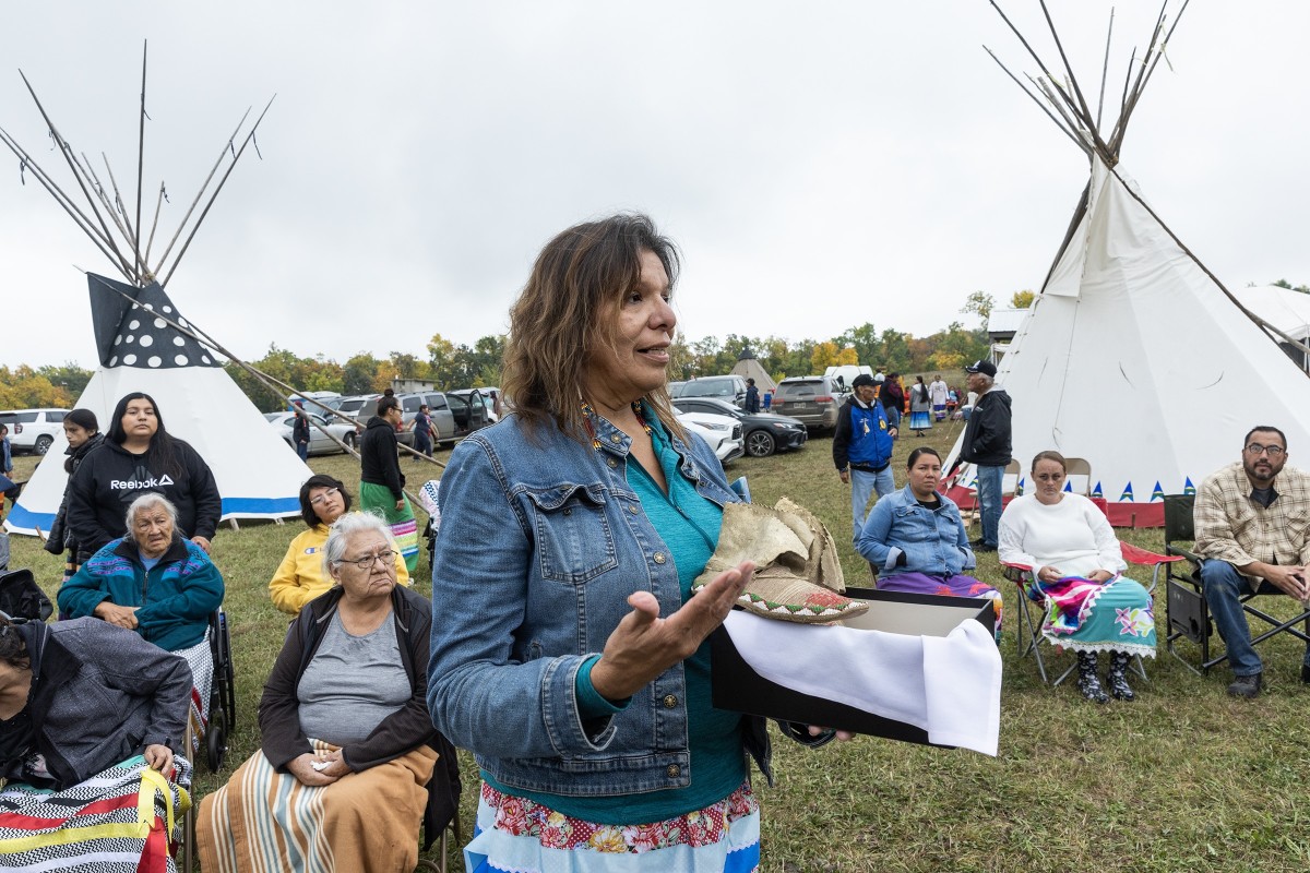 Kelley Bova, Sisseton Wahpeton Oyate, speaks to a gathering at the Lake Traverse Reservation in South Dakota on Sept. 23, 2023, after bringing home a pair of moccasins confiscated from an unknown Native boy at the Carlisle Indian Industrial School more than 100 years ago. They had been in the possession of Pennsylvania family for more than a century. (Photo by Charles Fox for ICT)