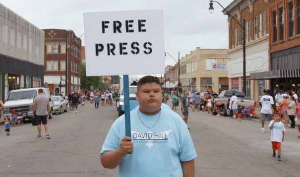 A young person holds a sign that reads “Free Press” while walking in a parade captured in the documentary "Bad Press." (Photo courtesy of "Bad Press")
