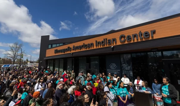 Hundreds of people listen to executive director Mary LaGarde welcome guests to the grand re-opening of the Minneapolis American Indian Center on Wednesday. (Ben Hovland, MPR News)